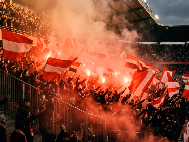 Tribune ultras supporters foot avec drapeaux et fumigènes dans un stade Ligue 1