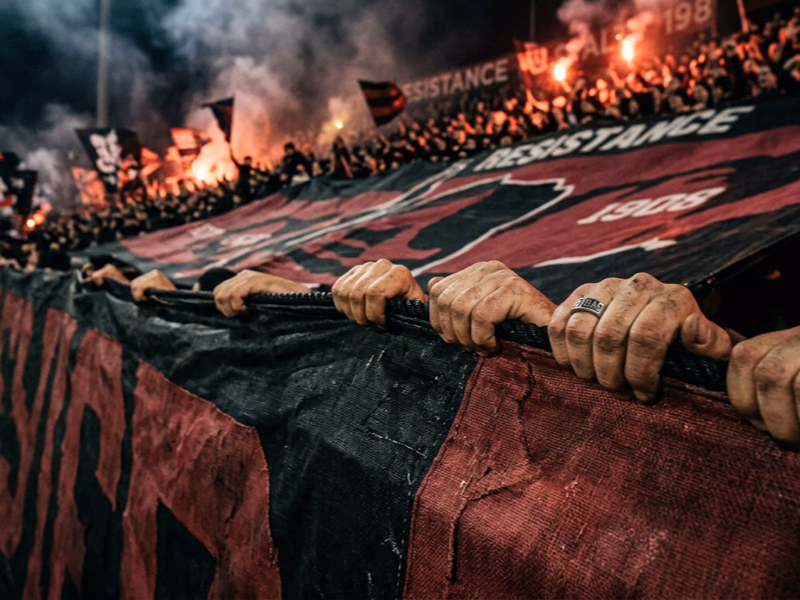 Supporters déployant un tifo rectangulaire XXL en tribune